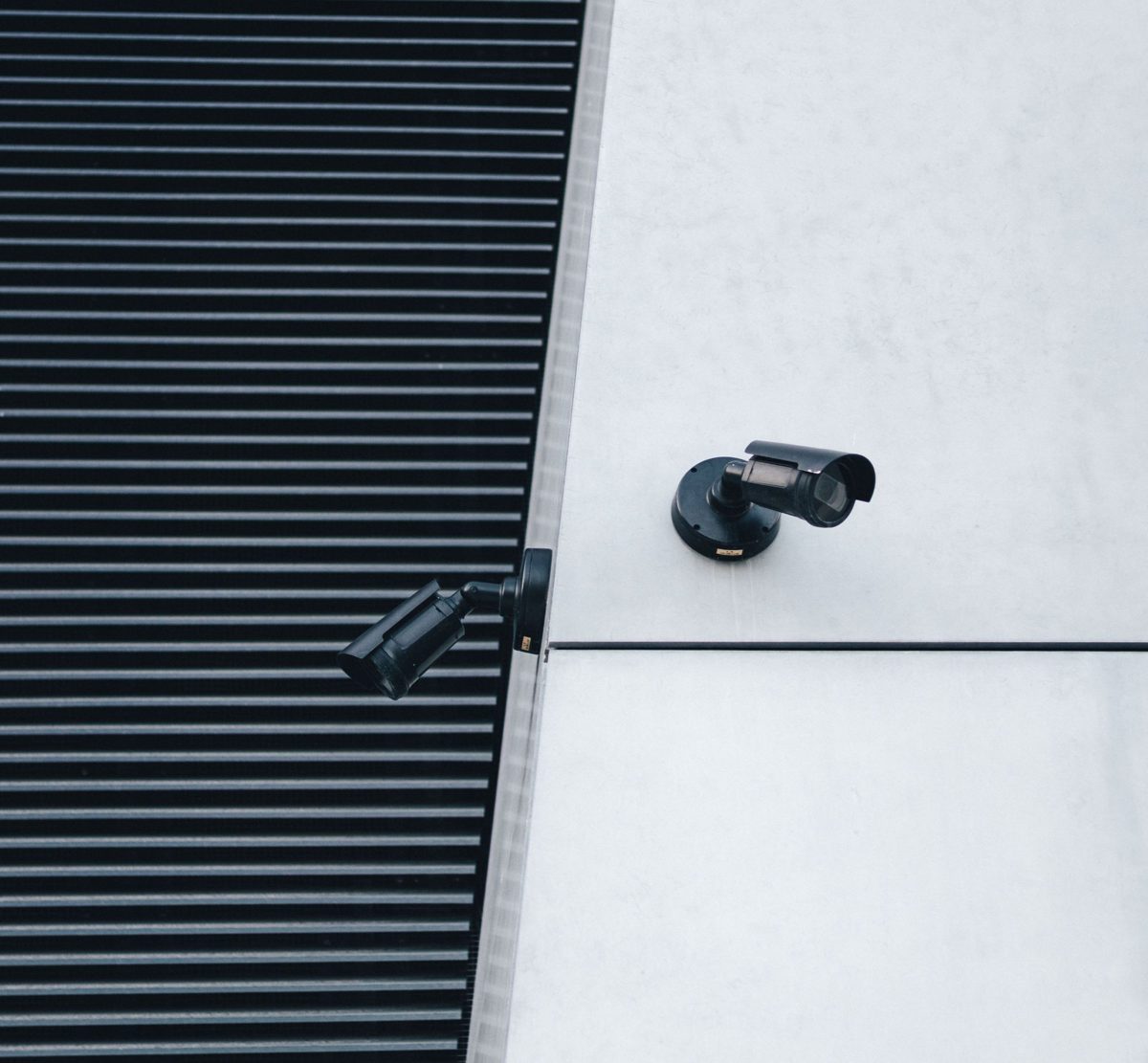 Two security cameras mounted on the corner of a building.