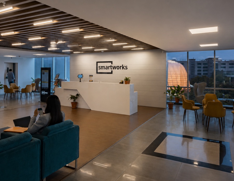 A corporate campus reception lounge with seating and a branded desk.